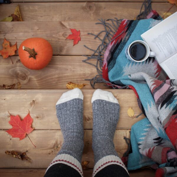 a girl reading a book and having coffee on a fall morning