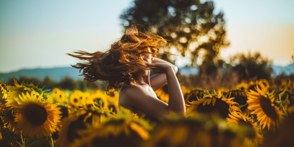 woman-standing-in-middle-of-sunflower-field