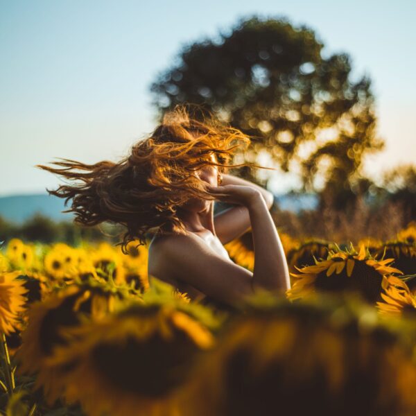 woman-standing-in-middle-of-sunflower-field