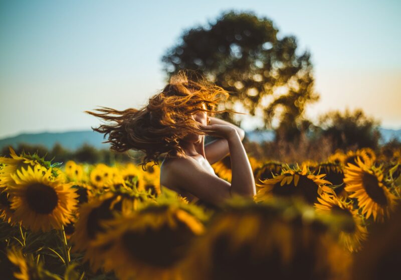 woman-standing-in-middle-of-sunflower-field