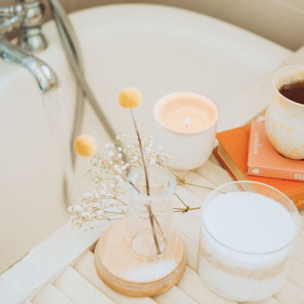 an image of self-care products like candles, bath salts, flowers, books