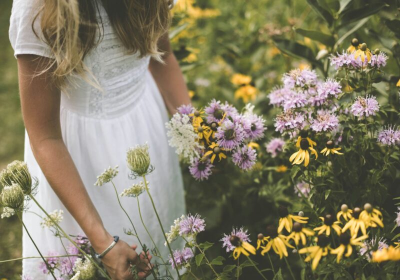 a girl living a simple life, playing with flowers in the garden
