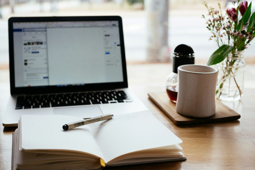 Productivity journal laptop and coffee on table