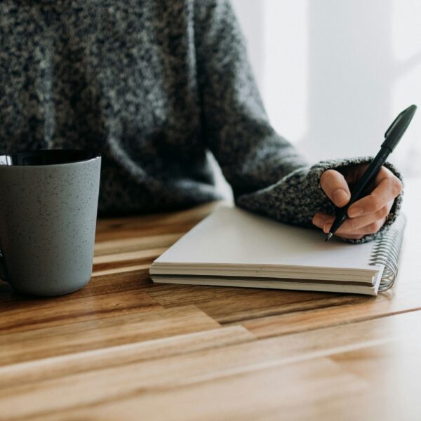 a girl writing in her journal while having coffee