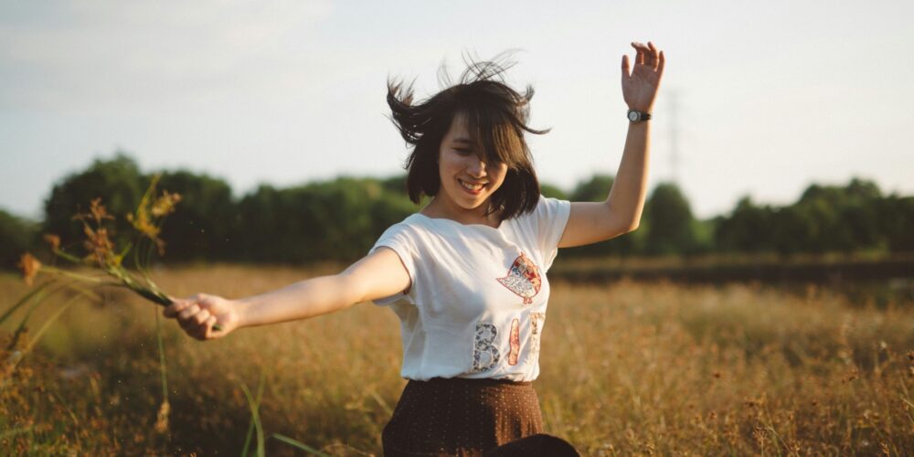 a girl living a happy life while holding flowers in her hand