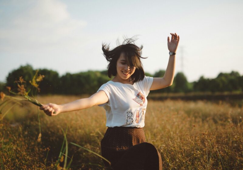 a girl living a happy life while holding flowers in her hand