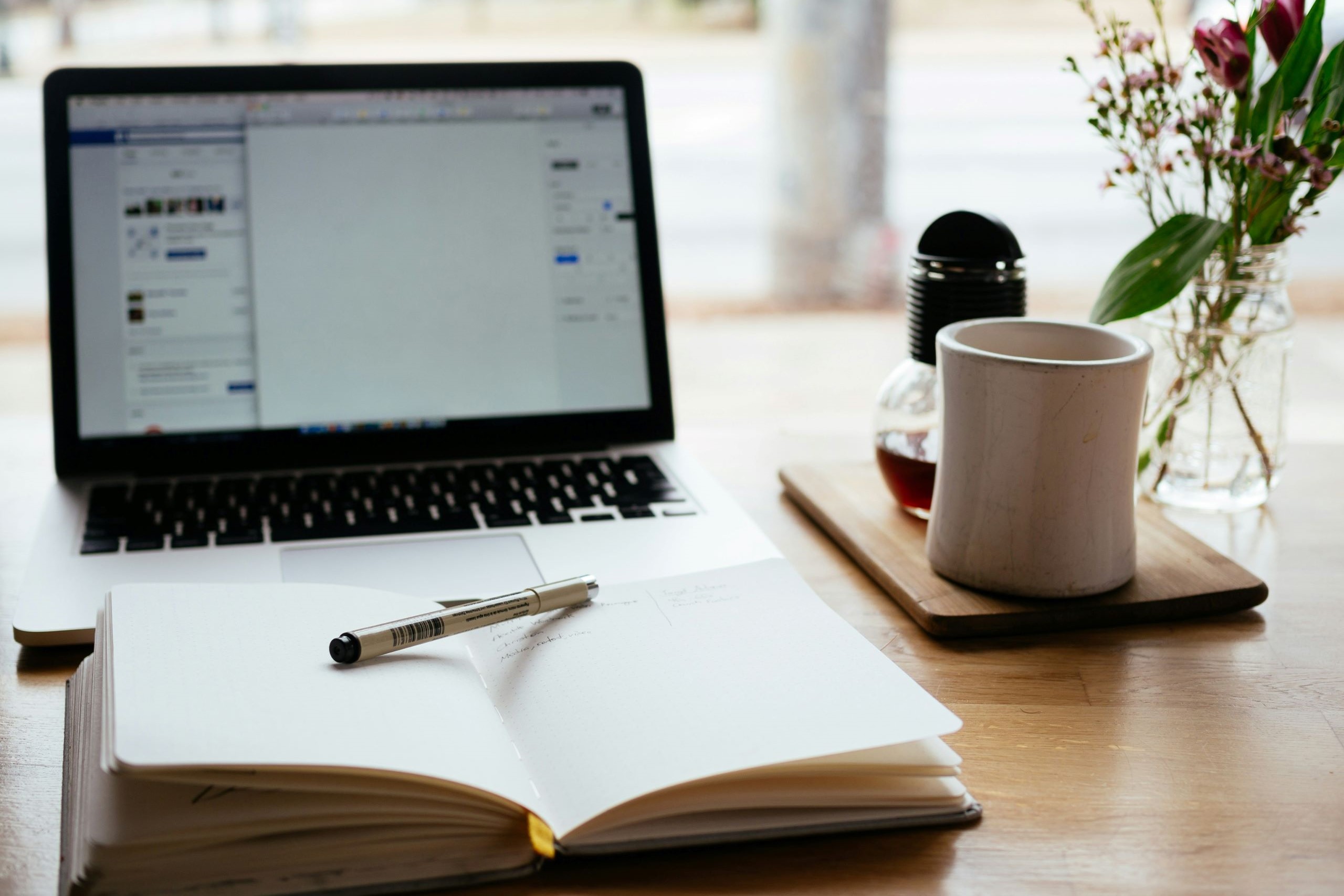 macbook near a diary notebook