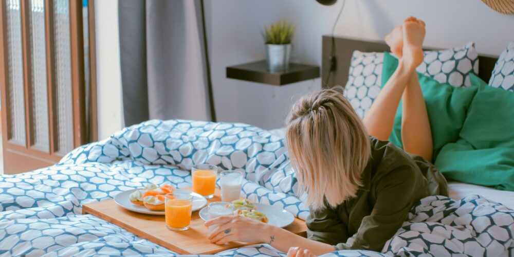 woman lying on bed practicing self-care