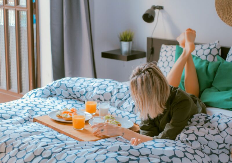 woman lying on bed practicing self-care