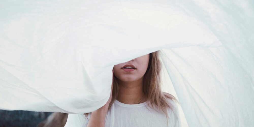 woman under white cloth being mindful