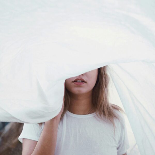 woman under white cloth being mindful