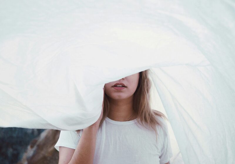 woman under white cloth being mindful