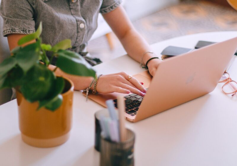 a productive woman sitting at a table using a laptop