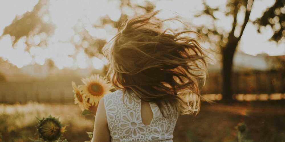 woman holding sunflower living a slow and simple life