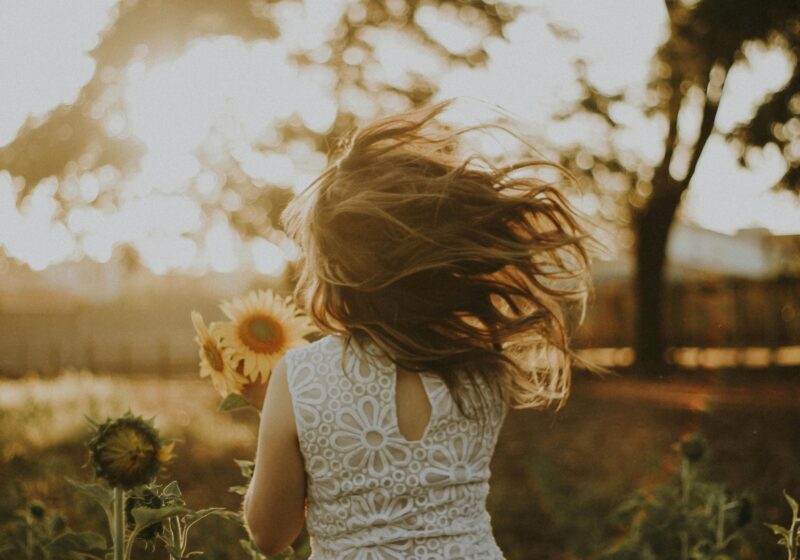 woman holding sunflower living a slow and simple life