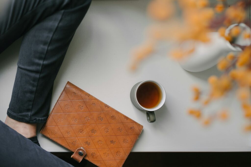 a women sitting at a table wondering what should she write in her journal