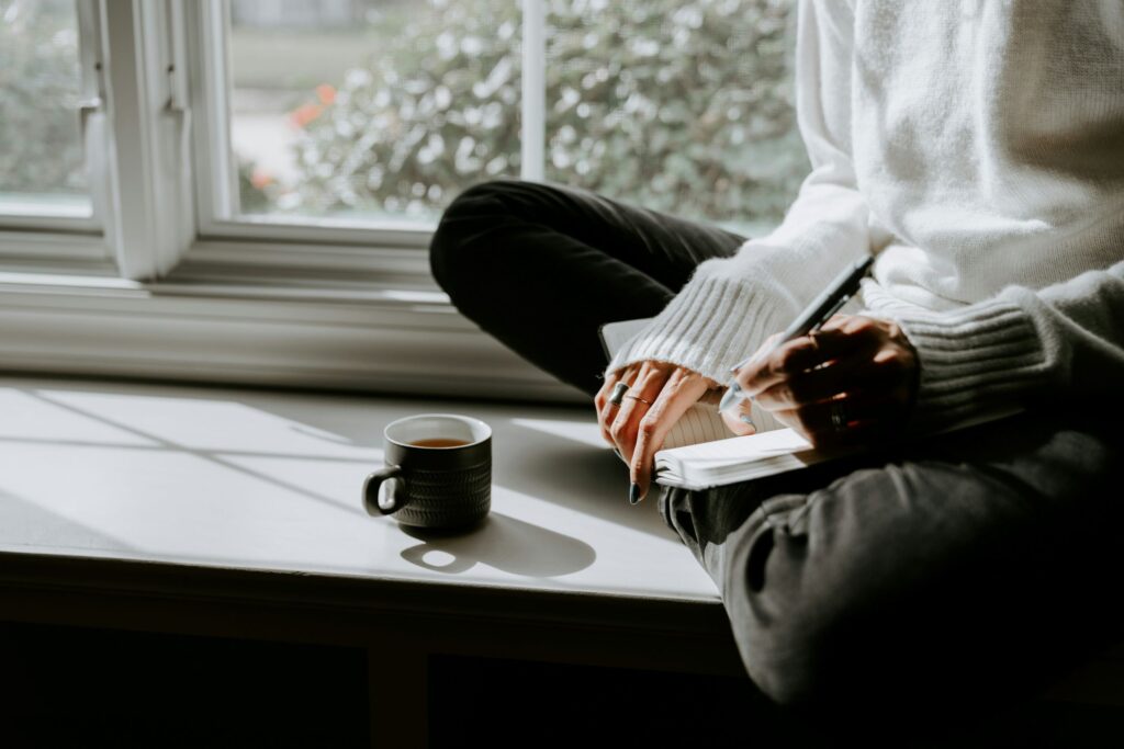 a girl journaling in the morning while having tea