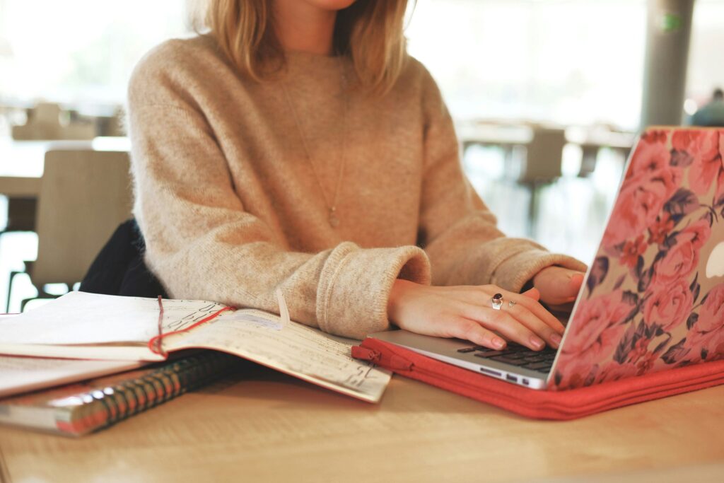 This image shows a woman working on her laptop, fully focused on her task. It represents practicing mindfulness at work by staying present and minimizing distractions.
