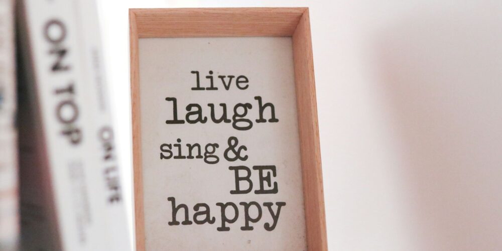 This image captures a simple and cheerful morning vibe with a framed quote that says, "Live, laugh, sing, and be happy," reminding you to embrace joy every day.