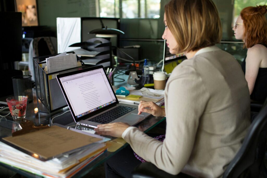 A female professional working on her laptop with calm focus, visually representing how mindfulness at work can help you manage stress and stay present during a busy workday.