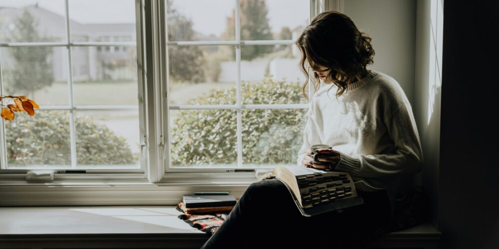 A woman enjoying a quiet, mindful coffee moment at home, embracing stillness and presence. This peaceful scene represents slow living, awareness, and everyday tips for a more awakened life rooted in simplicity and conscious pauses.