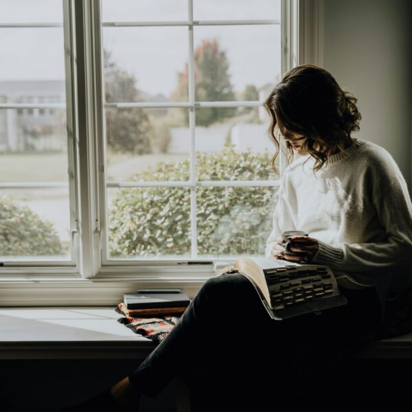 A woman enjoying a quiet, mindful coffee moment at home, embracing stillness and presence. This peaceful scene represents slow living, awareness, and everyday tips for a more awakened life rooted in simplicity and conscious pauses.