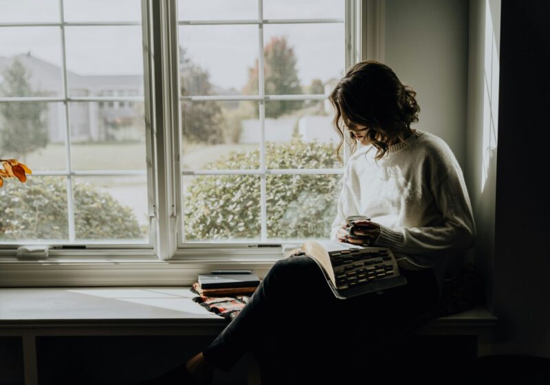 A woman enjoying a quiet, mindful coffee moment at home, embracing stillness and presence. This peaceful scene represents slow living, awareness, and everyday tips for a more awakened life rooted in simplicity and conscious pauses.